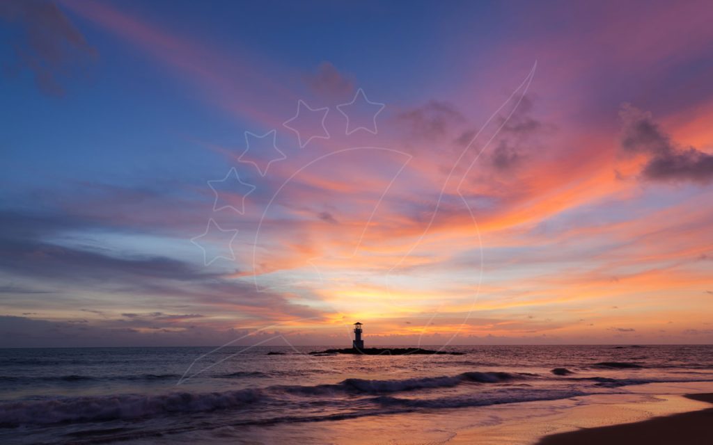 Farol em contraluz num quebra-mar rochoso ao pôr do sol, céu rosa e laranja sobre ondas numa praia de areia