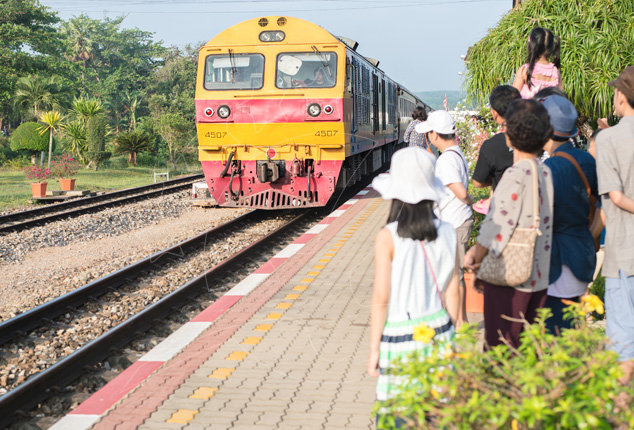 Locomotiva diesel amarela e vermelha n.º 4507 a aproximar-se da plataforma enquanto viajantes esperam junto aos carris