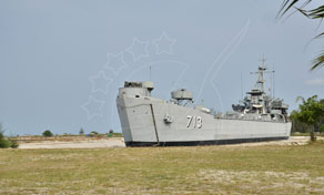 Navio de guerra cinzento desativado com o número de casco 73 assente na relva como memorial em terra