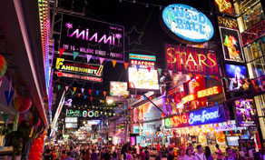 Multidões enchem uma rua de vida noturna iluminada por néon, com letreiros de bares e clubes — Walking Street, Pattaya, Tailândia