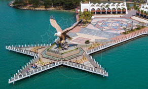 Vista aérea de uma escultura gigante de águia num cais branco em forma de estrela junto ao mar turquesa, Langkawi