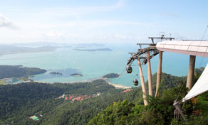 Cabina de teleférico e plataforma panorâmica no cimo do monte acima de encostas arborizadas com vista para mar turquesa e ilhas tropicais