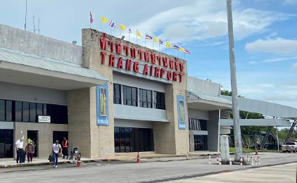 Terminal de ferries moderno com letreiro vermelho e bandeiras, em plena luz do dia
