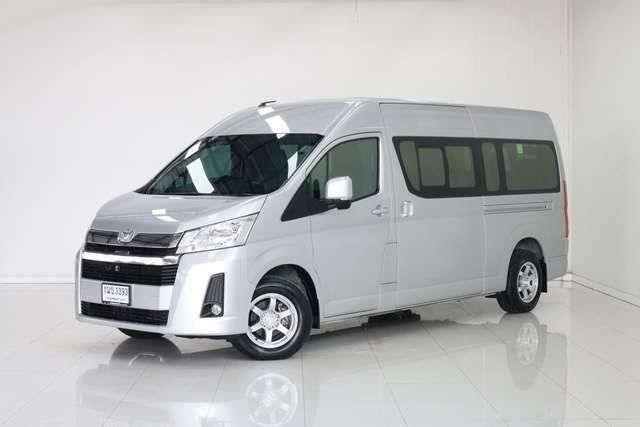 Van de passageiros Toyota Hiace prateada de teto alto com matrícula tailandesa num showroom de estúdio branco