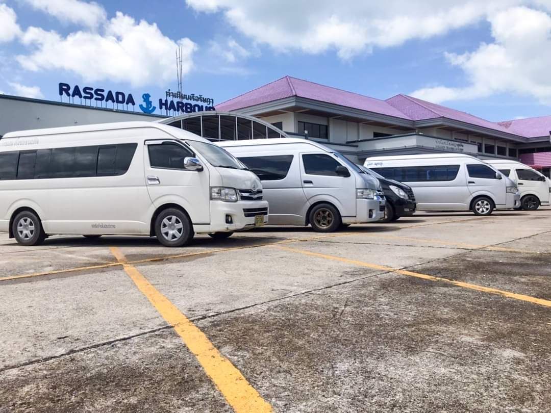 Fila de carrinhas brancas no parque junto ao terminal de ferries de Rassada, Phuket, sob céu azul