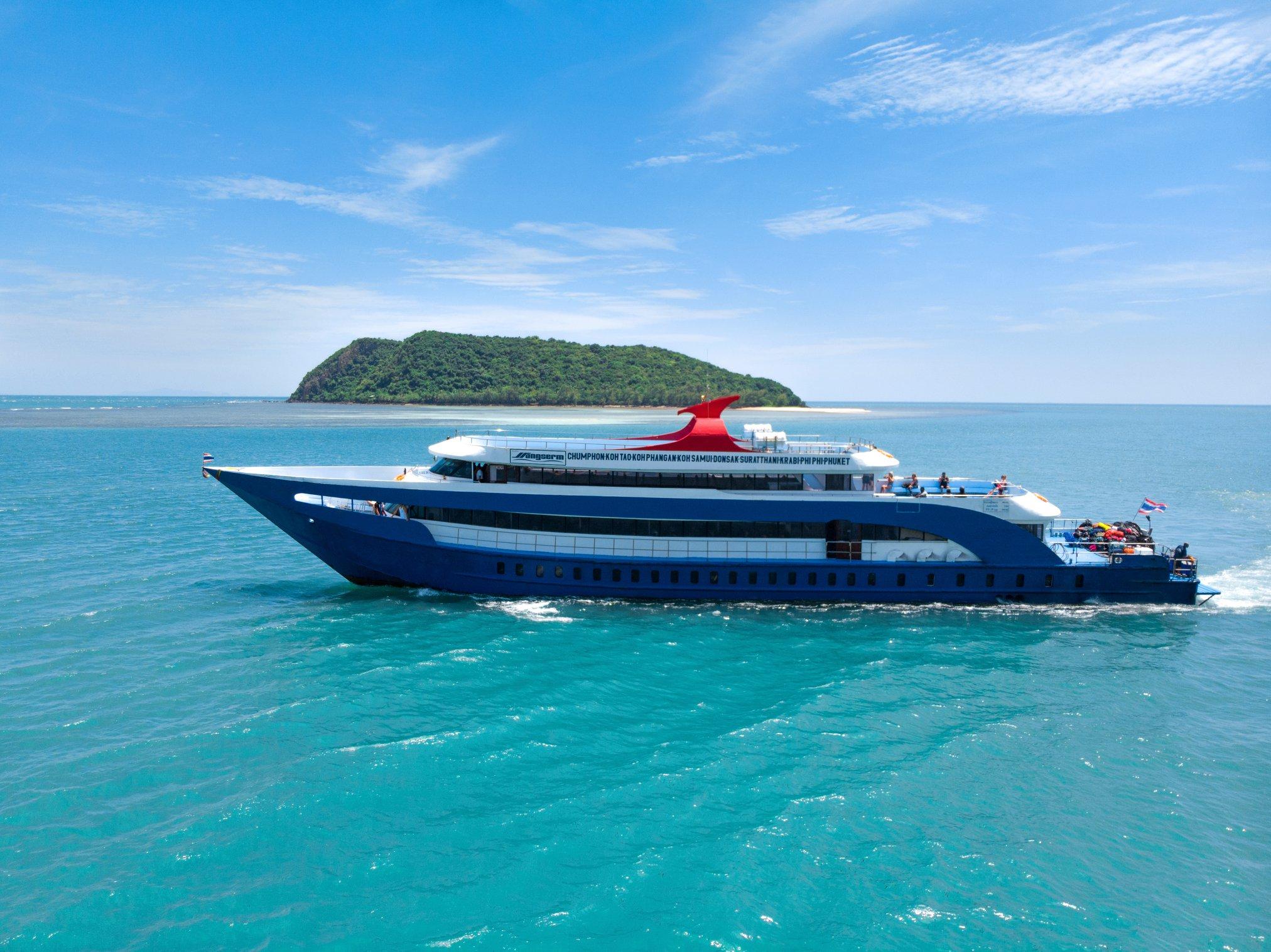 Ferry de passageiros Songserm azul e branco a navegar em mar turquesa junto a pequena ilha verde na Tailândia