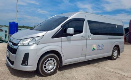 Carrinha de passageiros Toyota Hiace prateada estacionada na zona de transferes de um cais costeiro em plena luz do dia