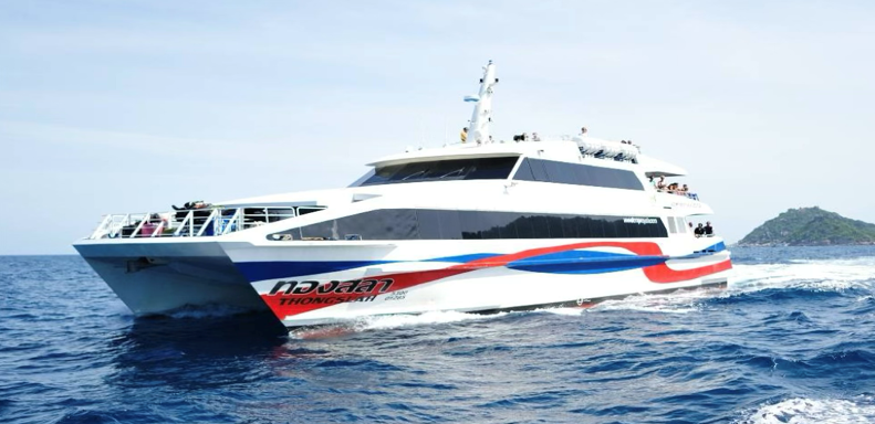 Ferry catamarã rápido branco com pintura vermelha e azul a navegar em mar azul-escuro aberto junto a uma ilha rochosa